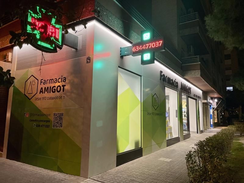 Farmacia Amigot de noche, con la cruz verde encendida, en Zaragoza